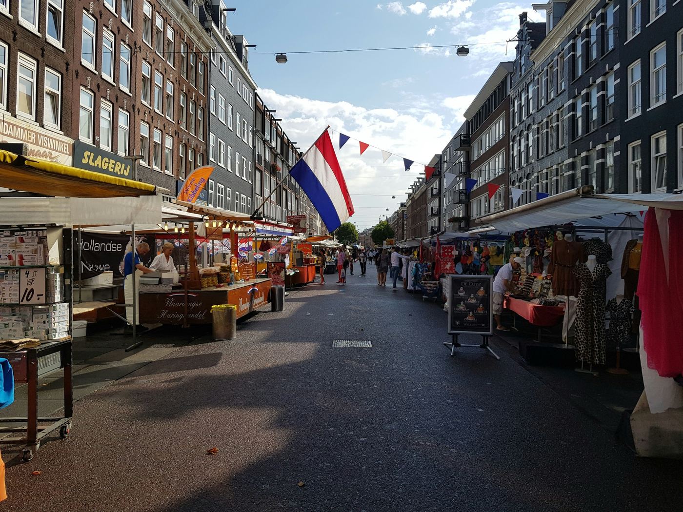 Albert Cuypmarkt in de Pijp with market stalls, a herring stand and a Dutch flag