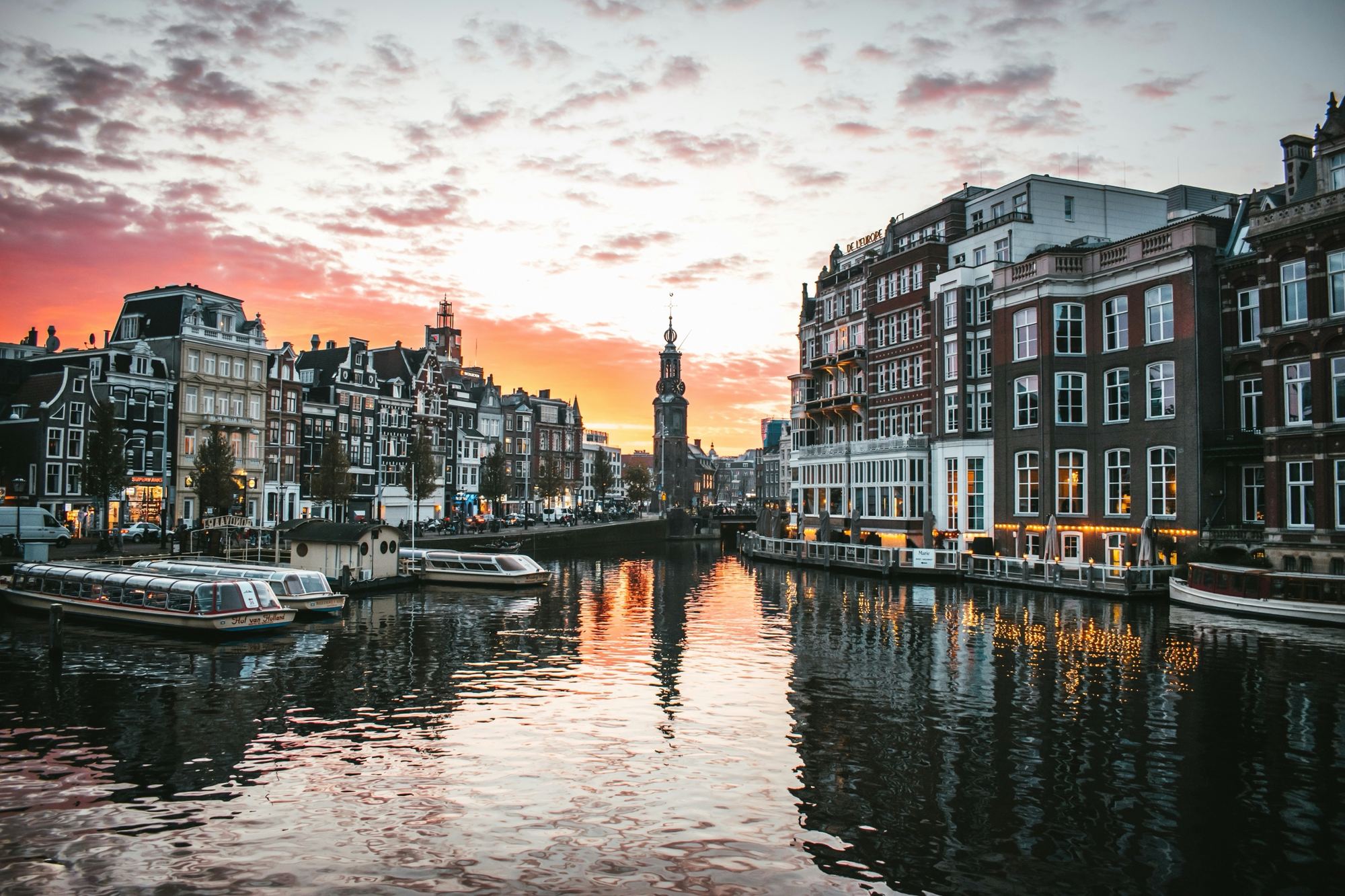 Sunset over the Amstel river with the Munttoren and canal houses reflected in the water