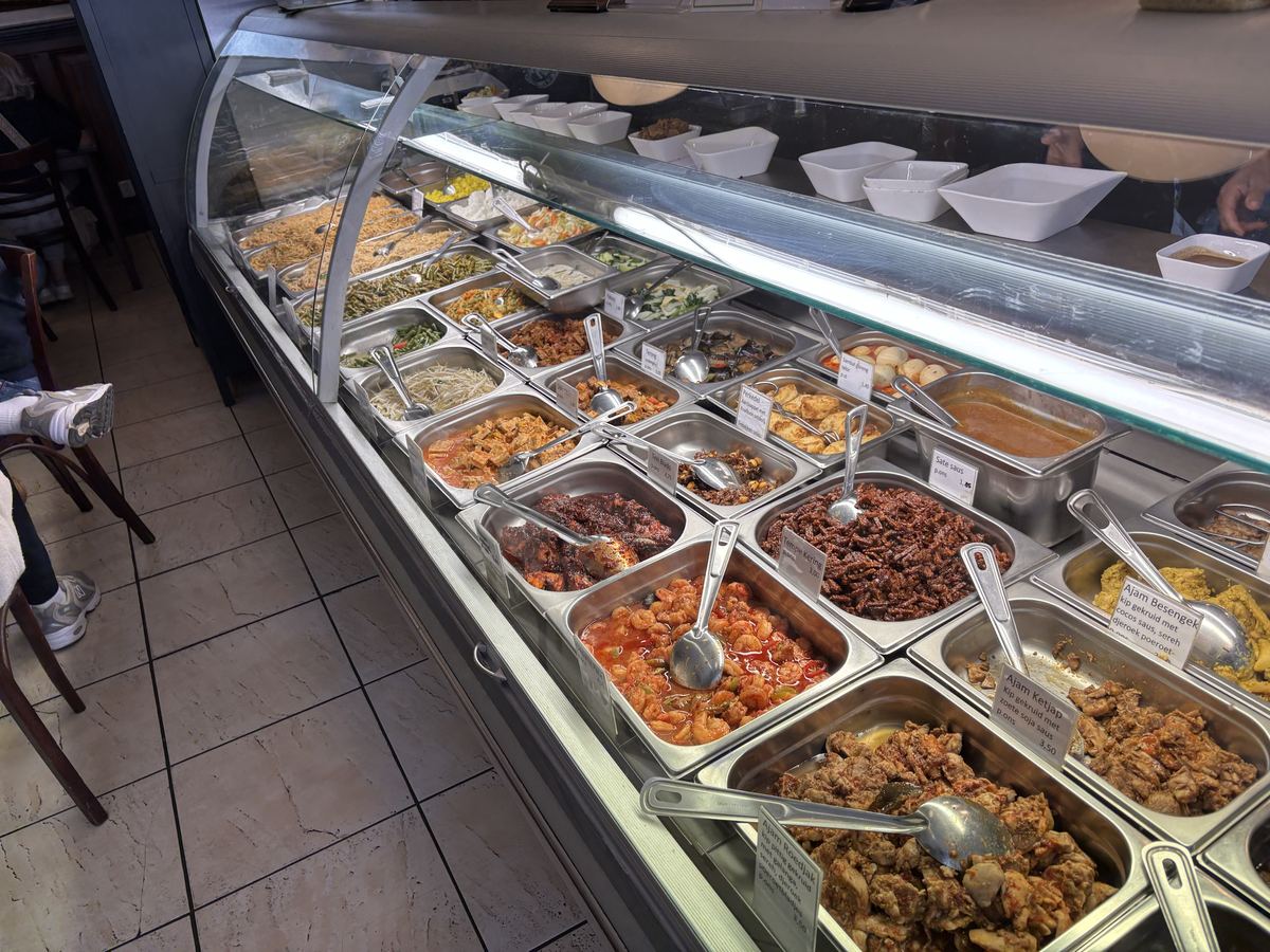 Display counter full of Indonesian dishes such as ajam ketjap, tempeh and sambal